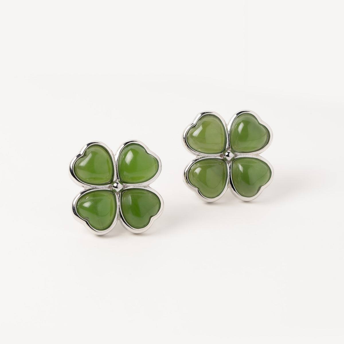 Green four-leaf clover earrings on a white background