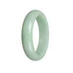A light green jade bangle with a half moon design, made of authentic untreated jadeite jade.