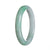 A close-up photo of a beautiful, apple green jadeite bangle bracelet. The bracelet is certified Type A and has a semi-round shape, measuring 63mm in diameter. It is a stunning piece of jewelry from MAYS™.