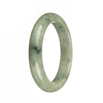 A stunning half-moon shaped green Burma Jade bangle, known for its natural beauty and authenticity. Perfect for adding a touch of elegance to any outfit.