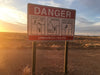 A warning sign in Coober Pedy, South Australia. The sign reads "danger, unmarked holes".