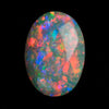 A black opal showing vibrant play of colour on a black background