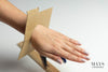 a woman's hand fitted with a cardboard bangle cutout. mays jade bangle sizing guide.