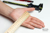 woman's palm being measured with a ruler. mays jade bangle sizing guide.