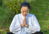 a photo of a woman meditating with jade bangle bracelets