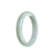 A close-up image of a pale green jadeite jade bangle bracelet in a half-moon shape, showcasing its natural beauty and authenticity.