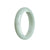 A half moon-shaped pale green Burma Jade bracelet, showcasing its natural beauty and elegance.