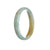 A pale green and yellow traditional jade bracelet in the shape of a half moon, measuring 58mm.