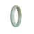 A half moon-shaped bangle bracelet made of certified untreated light green with olive green Burma Jade. The bracelet measures 56mm in size. Created by MAYS GEMS.