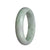 A beautiful light green Burmese jade bangle bracelet with hints of lavender, showcasing genuine Grade A quality. The bangle is shaped like a half moon and measures 58mm in diameter. A stunning piece from MAYS GEMS.
