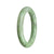 A round jade bangle with a natural green color, crafted in a traditional style.