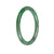 A close-up image of a small round green jade bracelet, measuring 58mm in size. The bracelet is made from genuine Grade A green jade and is delicately crafted. It features a smooth and polished surface, showcasing the beautiful natural color and texture of the jade stone. The bracelet is designed to be petite and elegant, perfect for adding a touch of sophistication to any outfit. The brand name "MAYS" is also mentioned, indicating the quality and authenticity of the product.