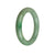 A round emerald green Jadeite bangle bracelet with a natural and vibrant green color.