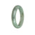 A close-up image of a green jadeite jade bangle with a half-moon shape, measuring 58mm. The smooth and untreated jade stone has a vibrant green color, exuding natural beauty and elegance. This exquisite accessory is a product of MAYS™.