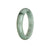 A close-up image of an authentic untreated bluish green jadeite jade bracelet. The bracelet features a half-moon shape and measures 56mm in diameter. Crafted by MAYS GEMS.