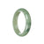 A close-up image of a half moon-shaped green jadeite bracelet with a smooth and polished surface. The bracelet is made from genuine untreated jadeite, showcasing its vibrant green color. The bracelet is 59mm in size and it has been skillfully crafted by MAYS™.