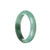A close-up photo of a light green bracelet made from certified Grade A Burma Jade. The bracelet has a half moon shape and features a deep green patch. It is 58mm in size and is a product of MAYS™.