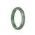 A close-up photo of a semi-round jade bangle in olive green color. It has a patterned texture, showcasing the natural beauty of the jade stone. The bangle has a smooth and glossy finish, and it measures 59mm in size. It is a genuine grade A jade bangle with high quality craftsmanship.