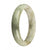 A beautiful half moon-shaped jade bangle bracelet with a mix of green, white, and brown spots, made from genuine Grade A jade.