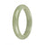 A close-up image of an elegant green jade bangle bracelet in a half moon shape, with a smooth surface and a glossy finish.