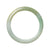 A round, light green jadeite jade bangle, measuring 63mm in size, crafted with genuine, natural materials. Perfect for adding a touch of elegance to any outfit.