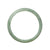 A close-up of a light green jadeite bangle bracelet with a smooth, semi-round shape. It is certified as Grade A quality and measures 57mm in diameter. Designed by MAYS™.