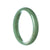 A half moon shaped jade bangle with a stunning natural green color, representing authenticity and tradition.