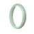 A half moon-shaped pale green jade bangle, showcasing the natural beauty and elegance of this rare gemstone.