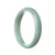 A close-up image of an exquisite pale green jadeite bracelet. The bracelet features a half-moon shape with a smooth and polished surface, showcasing the beauty of the Grade A jadeite. Crafted with authenticity and precision, this stunning piece by MAYS™ measures 57mm in diameter, making it a perfect accessory for any occasion.