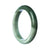 A close-up photo of a high-quality green Burmese jade bangle. The bangle has a smooth, semi-round shape and measures 77mm in diameter. It showcases the vibrant green color and exquisite craftsmanship of the jade. Perfect for adding a touch of elegance and natural beauty to any outfit.